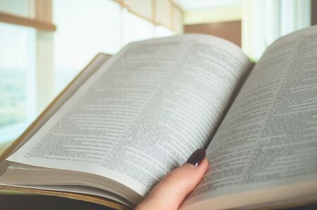 Bible on a background of home interior. The concept of faith, spirituality and religion. Peace, hope, dream conceptの写真素材