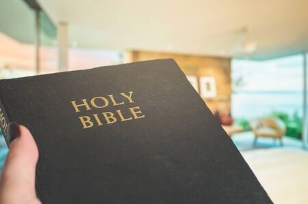 Bible on a background of home interior. The concept of faith, spirituality and religion. Peace, hope, dream conceptの写真素材