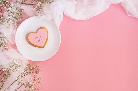Twigs of gypsophila and cookies with the inscription Love you  on a pink background. Spring background. Love conceptの写真素材