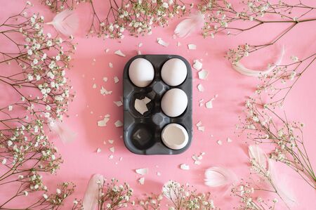 Happy Easter. Congratulatory easter background. Easter eggs with spring flowers gypsophila on a pink...