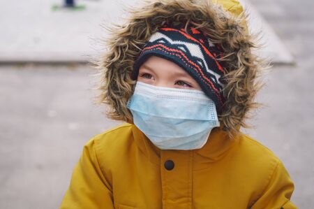 Coronavirus covid-19. Child in a protective mask on the street. Protection in prevention for coronavirus. COVID-19 Pandemic Coronavirusの写真素材