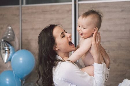 Woman hugging and playing with her little son on birthday. Mothers day, love, family, childhood conceptの写真素材