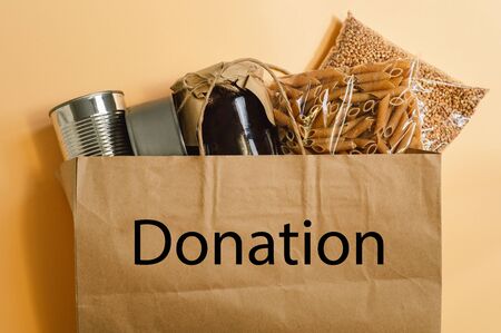 Donation. Food delivery. Coronavirus. Paper Grocery Bag with food supplies crisis food stock for quarantine.  Buckwheat, pasta, canned food. View from aboveの写真素材