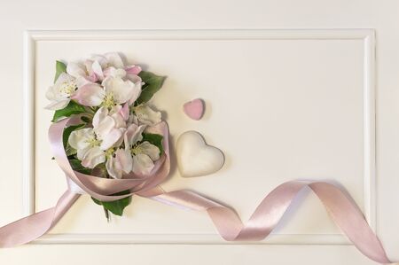 Spring apple blossom branches with hearts over white background. Top view, flat layの写真素材