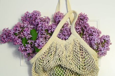 Blooming spring lilac flowers in string bag. Spring background.の写真素材