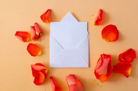The envelope greeting card, envelope with rose and petals. Overhead top view, flat lay. Copy space. Birthday, Mother's, Valentines, Women's, Wedding Day concept.の写真素材