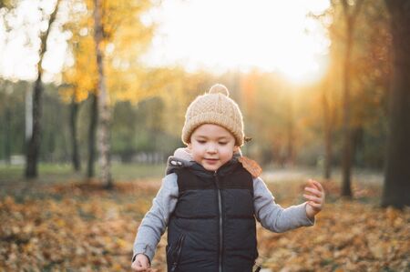 Happy little child baby boy laughing and playing in the autumn day.の写真素材