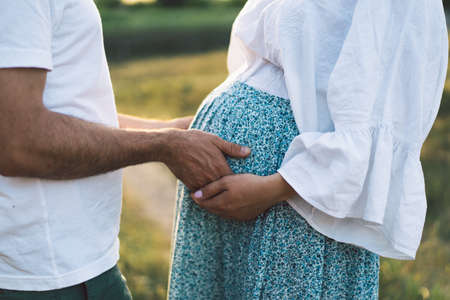 Happy and young pregnant couple in outdoors.の写真素材