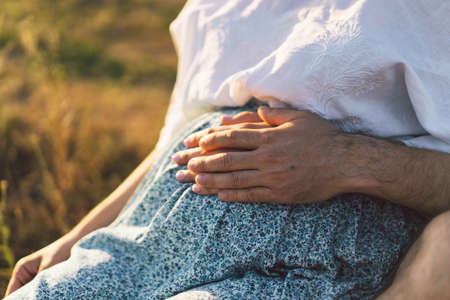Happy and young pregnant couple in outdoors.