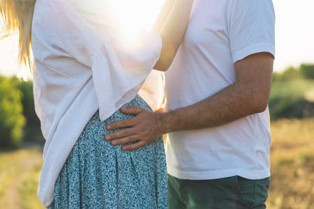 Happy and young pregnant couple in outdoors.の写真素材