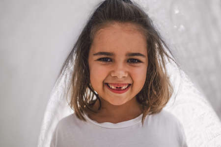 Happy child. Funny girl playing with a blanket. Smiling child girl. Cheerful hild outdoors in...