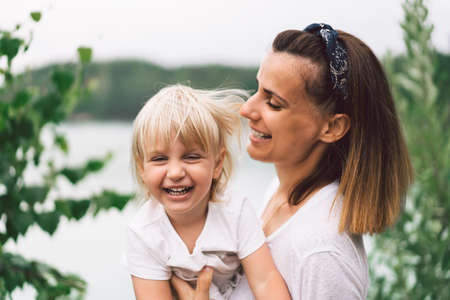 Young mother holding her baby. Mother and  little daughter  having good time in the nature. Mothers...