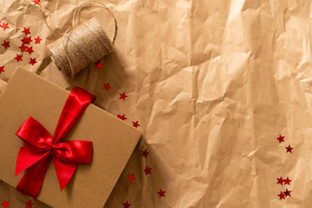 Gift box and Christmas decor on craft paper background. Winter festive composition with Christmas...