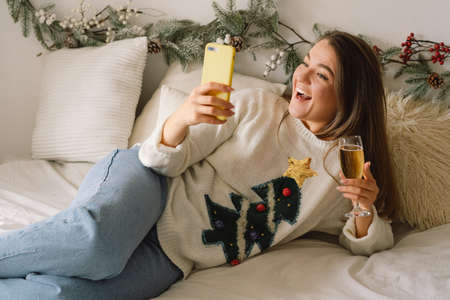 A beautiful girl meets Christmas (New Year) through a video call with friends. Quarantine....