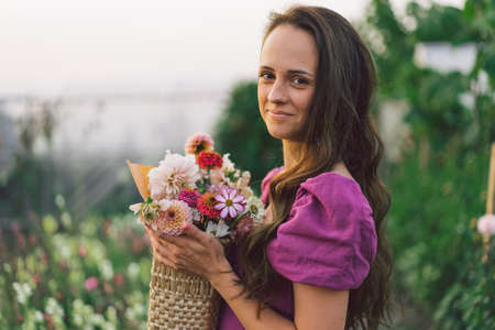 Portrait girl with long hair with a flower basket. Walk in the flower garden. Girl and flowers....