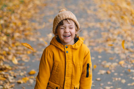 Happy little child baby boy laughing and playing in the autumn on the nature walk outdoorsの写真素材