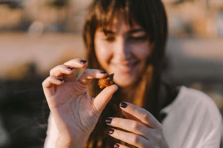 Inhabitants of the sea. The girl holds a sea inhabitant in a shell on her hand. Vacation and vacation at sea.の写真素材
