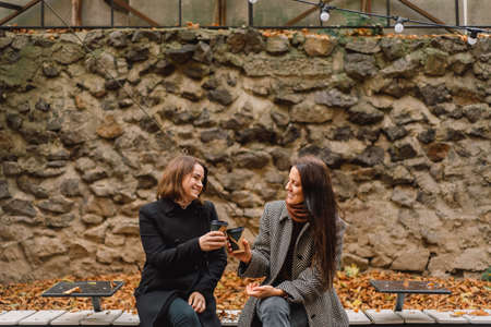 Girls drinking coffee in the park. Friends and lifestyle