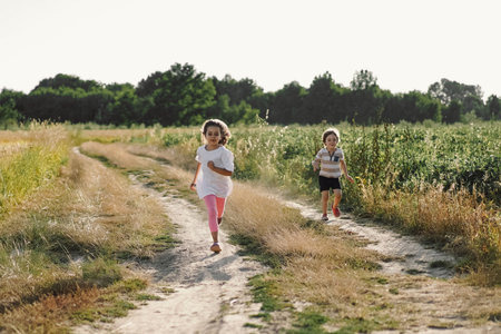 Happy children running on meadow in summer in nature.の写真素材