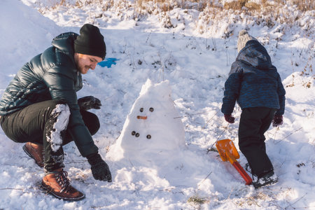 Happy dad and little boy playing with snow. Winter holiday.の写真素材