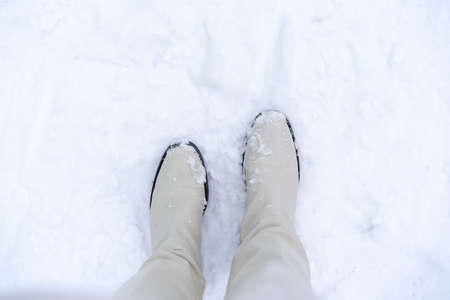 White boots in the snow. Winter walking in snow. Pair of shoes.の写真素材