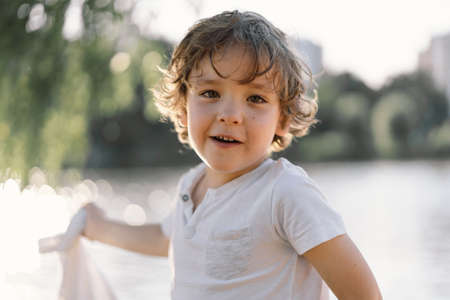 Portrait of a cute boy playing in nature near the river.の写真素材