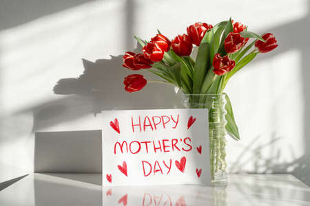 Happy Mother's Day. A bouquet of red tulips on the dresser in the living room.