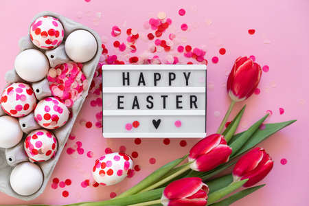 Happy Easter. Easter eggs decorated with paper confetti and tulipsの写真素材