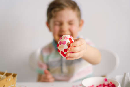 A little boy in bunny ears decorates Easter eggs. Easter concept. Spring season