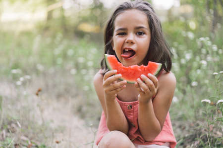 The girl is eating a watermelon. Childhood Summer mood.の写真素材
