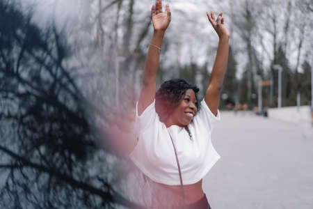 Photo portrait of cheerful black skinned girl. Afro girl dance in city park. Lifestyle