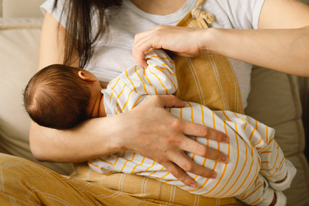 Newborn baby boy sucking milk from mothers breast. Portrait of mom and breastfeeding baby. Concept...
