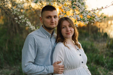 Young beautiful couple hugging in the spring garden.の写真素材