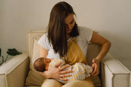 Newborn baby boy sucking milk from mothers breast. Portrait of mom and breastfeeding baby. Concept...