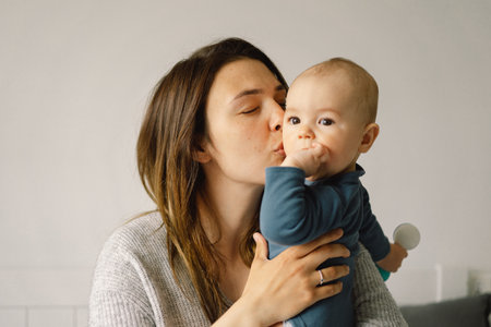 A young mother is play with little baby boy. Mother of a nursing baby. Happy motherhood. The family is at home. Portrait of a happy mother and child.の写真素材