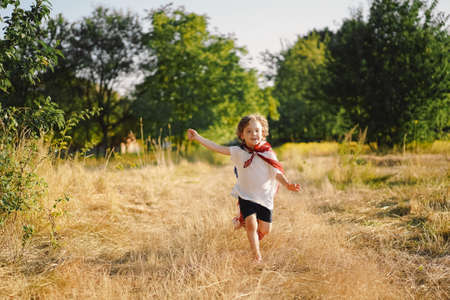 Happy little boy patriot running in the field with American flag. USA celebrate 4th of Julyの写真素材