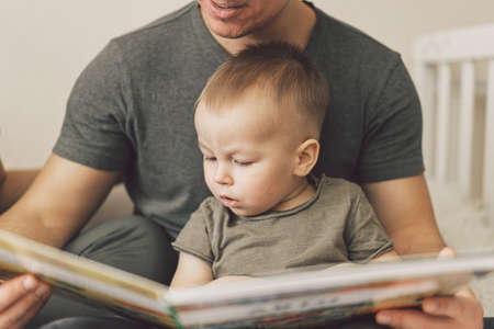 Family Love. Parents and Little Son Reading Book Together At Home In Bed Room. Family life is about fun.の写真素材
