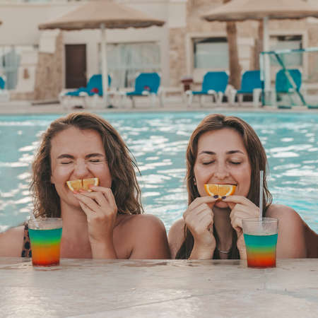 Group of beautiful young women have a rest on a pool. Friends rest on the pool and laughing on a...