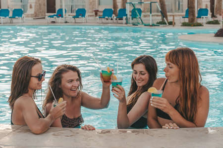 Group of beautiful young women have a rest on a pool. Friends rest on the poolの写真素材