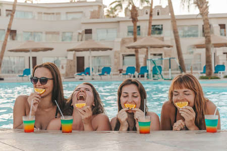 Group of beautiful young women have a rest on a pool. Friends rest on the poolの写真素材