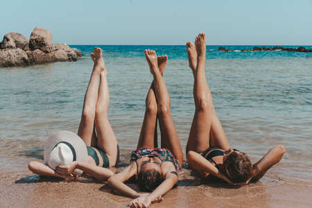 Group of beautiful young women have a rest on a beach. Friends walking on the beachの写真素材