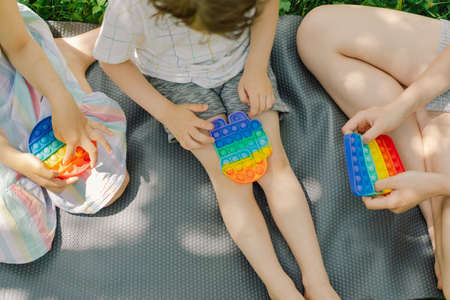 Kids is playing with new trendy toy. Development of fine motor skills, Push bubble fidget sensory toy washable and reusable silicon stress relief toy.の写真素材