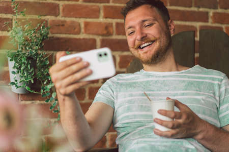 Young man laughs and talking by video call on the phone.の写真素材