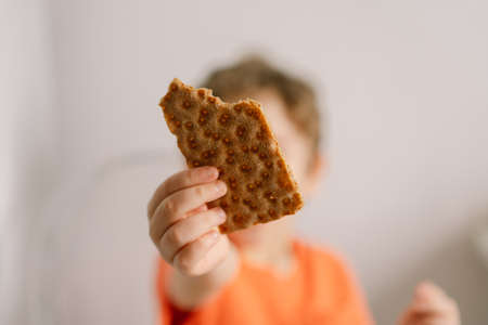 Cute little boy eats crispbread. Healthy lifestyle and nutrition concept.