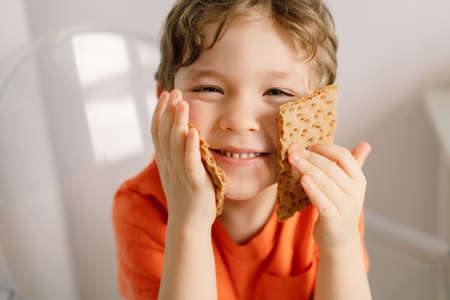 Cute little boy eats crispbread. Healthy lifestyle and nutrition concept.の写真素材