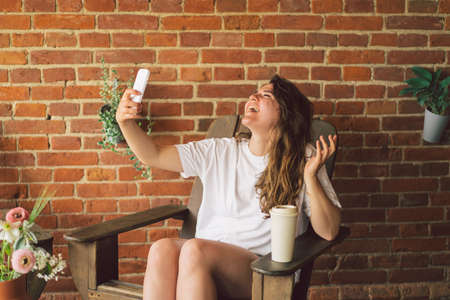 Young woman laughs and talking by video call on the phone. The concept of lifestyle mobility