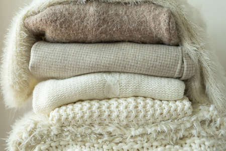 Pile of knitted sweaters. Warm background, knitwear, space for text. Autumn winter concept....