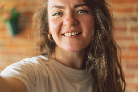 Young woman smiling and looking in camera and takes a selfie. Lifestyle concept