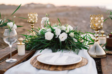 Luxury decorated table for a romantic date. Festive details tablecloth, candles, plates, glassesの写真素材