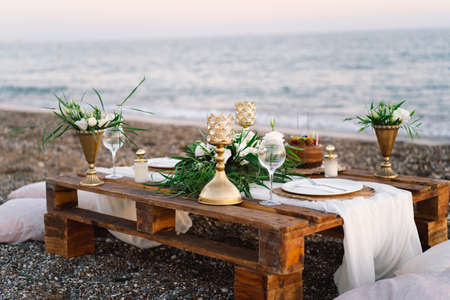 Luxury decorated table for a romantic date. Festive details tablecloth, candles, plates, glassesの写真素材